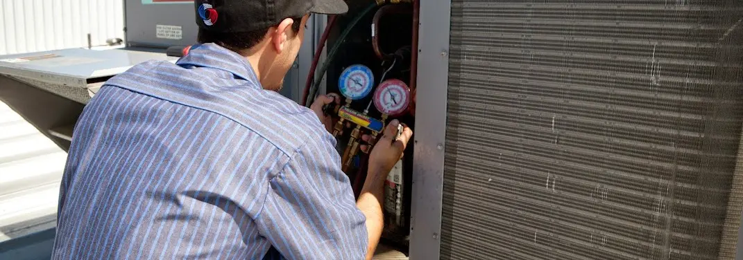 HVAC technician servicing a condenser unit in Archdale