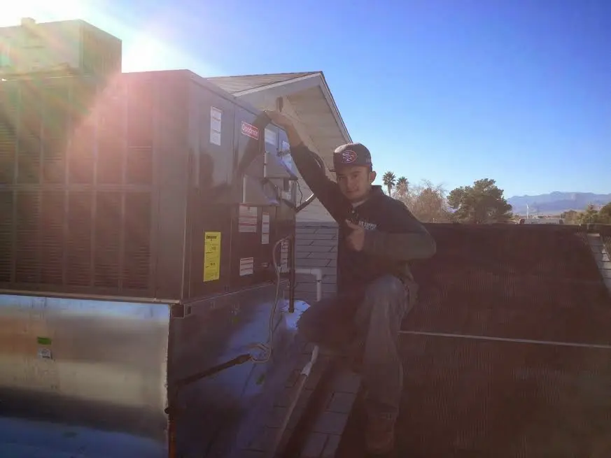 HVAC technician performing Air Duct Cleaning on a rooftop unit in Archdale